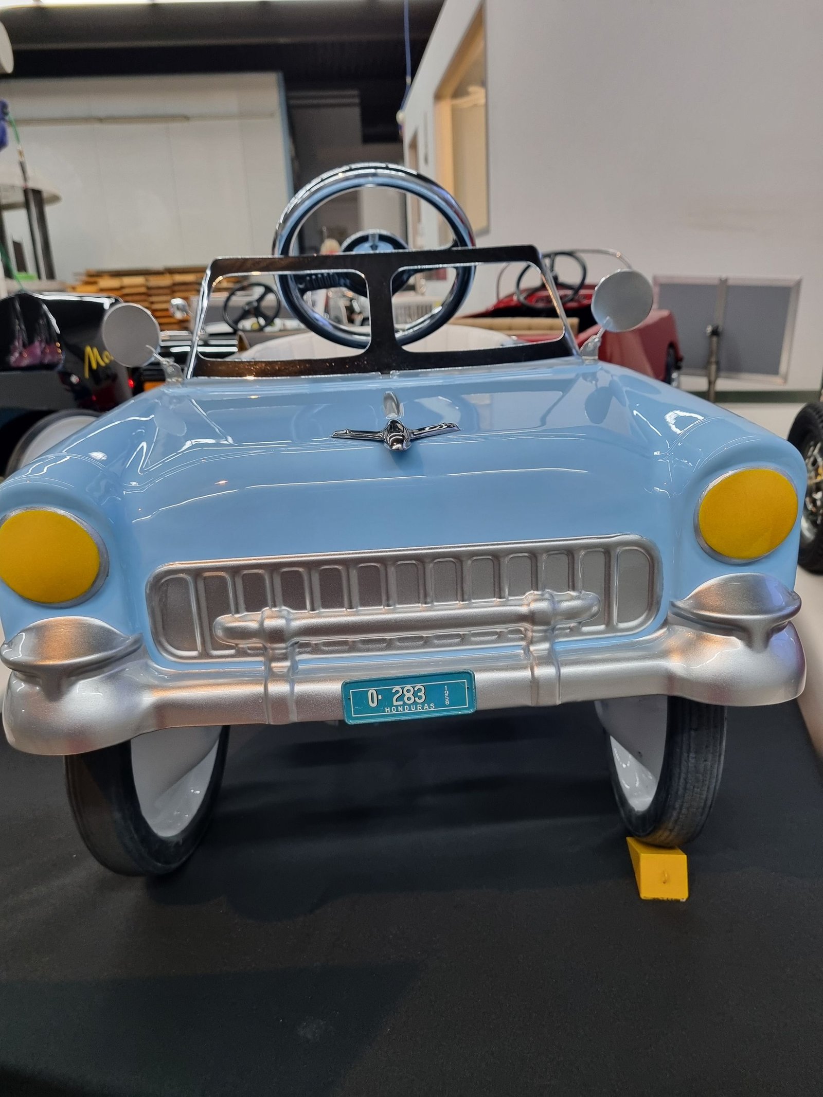 Ein hellblaues Tretauto mit einem Nummernschild mit der Aufschrift „tcc“